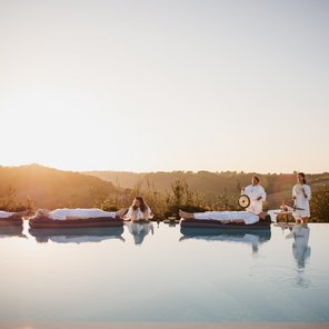 Vier Ayurveda-Gäste nehmen an einer Klang-Meditation auf dem Wasser teil