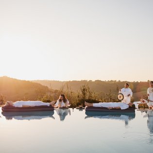 Vier Ayurveda-Gäste nehmen an einer Klang-Meditation auf dem Wasser teil