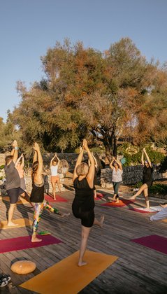 Balance Übungen in der Gruppe unter blauem Himmel