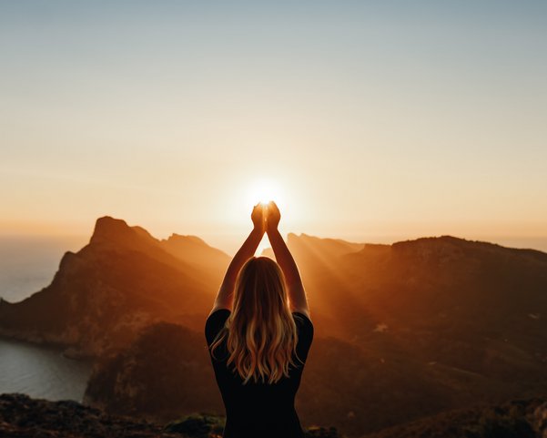 Junge Frau übt Yoga bei Sonnenuntergang