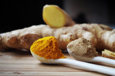 Zwei Teelöffel mit Kurkuma- und Ingwerpulver