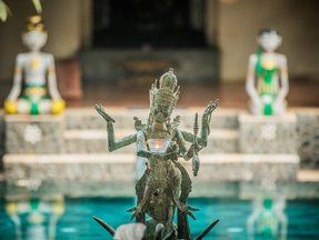 Eine balinesische Statue vor einer Resortanlage