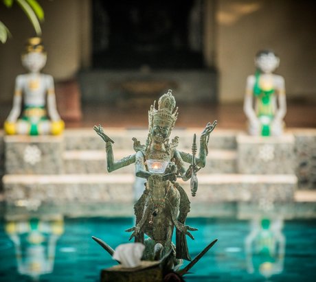 Eine balinesische Statue vor einer Resortanlage