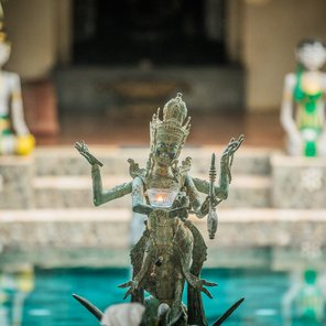 Eine balinesische Statue vor einer Resortanlage