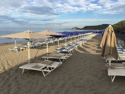 Mit einem Buch am Strand nahe des Resort Roccamare entspannen