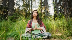 meditation-urlaub-wiese-schneidersitz-frau Meditatives Yoga im Grünen