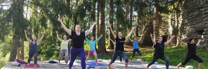 Üben Sie gemeinsam auf der Yoga-Plattform mitten im Grünen