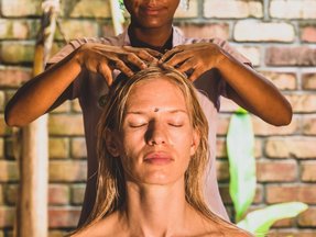 Eine Frau erhält eine ayurvedische Kopfmassage