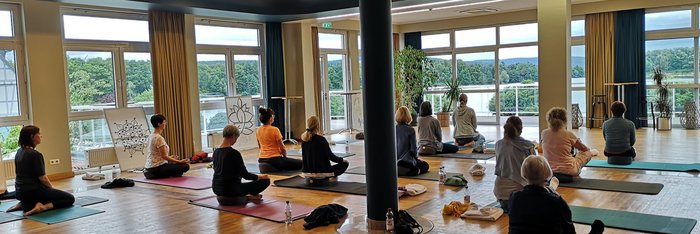 Üben Sie gemeinsam Yoga im hellen Yogaraum