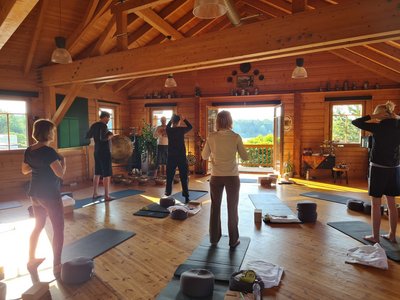 Gemeinsam mit Blick auf den See Yoga üben