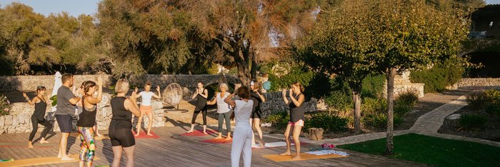 Yoga Übende auf einer Yogaplattform unter blauem Himmel