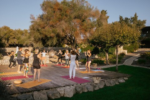 Yoga Übende auf einer Yogaplattform unter blauem Himmel