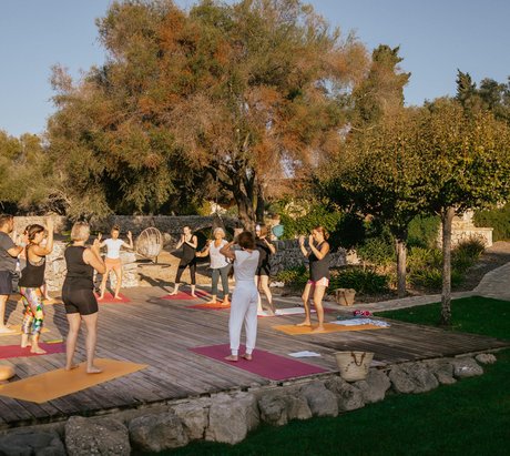 Yoga Übende auf einer Yogaplattform unter blauem Himmel