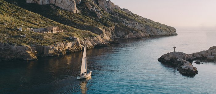 Ein Segelboot in einer Bucht zwischen Felsen