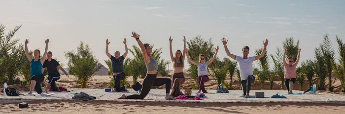 Yogaplattform in der Wüste mit Yogis