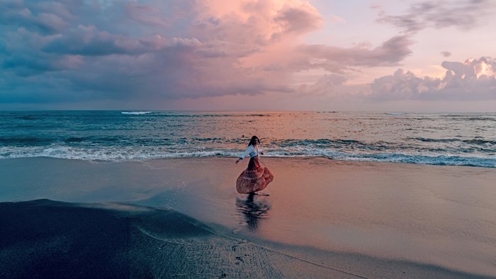 Frau Tanz am Strand bei Sonnenuntergang
