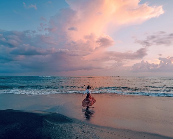 Frau Tanz am Strand bei Sonnenuntergang