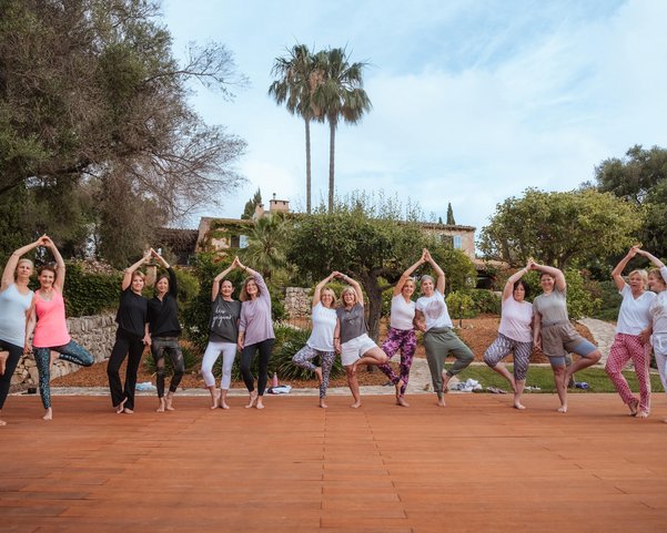 Yoga Gruppe übt gemeinsam Baum Asanas