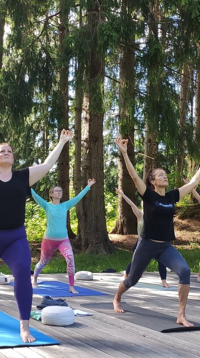Üben Sie gemeinsam auf der Yoga-Plattform mitten im Grünen
