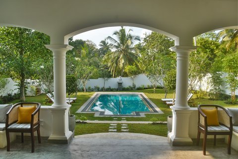 Stilvoll und symmetrisch schmiegt sich der Pool in den Garten des Shanthi Lanka