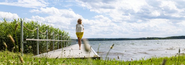 Frau auf dem Steg am See