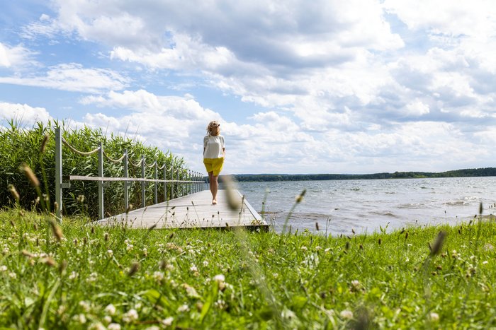 Frau auf dem Steg am See