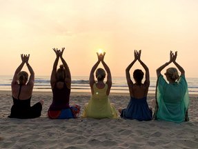 Yoga Gruppe am Strand bei Sonnenuntergang