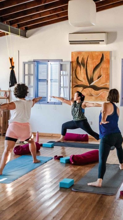 Mit Gleichgesinnten Yoga üben im hellen Yoga-Raum