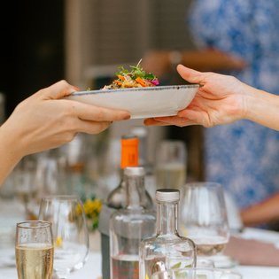 Ein Teller mit Essen wird weitergereicht