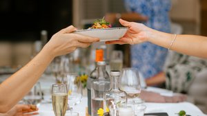 Ein Teller mit Essen wird weitergereicht