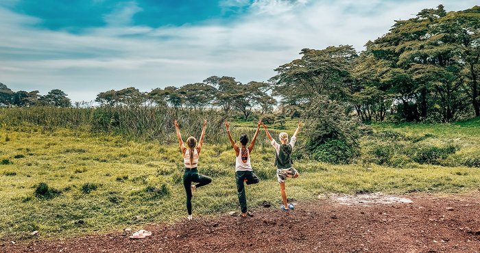 Frauen üben Yoga in der Landschaft Tansanias