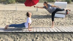 yoga-reisen-deutschland-baltrum-naturhotel-baltrum-yoga-pose-regenschirm-strand Den Moment nutzen - der mitgebrachte Regenschirm wird kurzerhand in die Yoga-Übungen integriert...