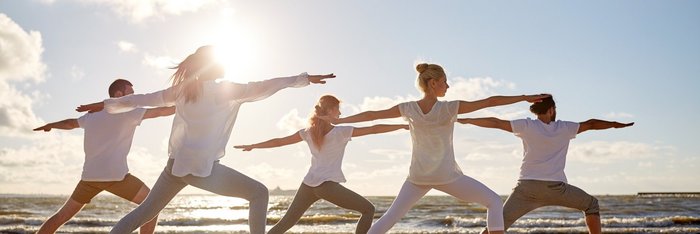 Üben Sie Yoga gemeinsam am Strand mit Gleichgesinnten