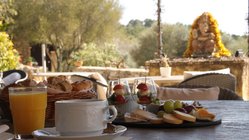 yoga-reisen-spanien-mallorca-finca-son-mola-vell-essen Auf der Terrasse der Yoga Finca Son Mola Vell begrüßt Sie unser Ganesha bei Sonnenschein und leckerem Frühstück