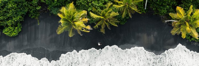 Schwarzer Strand mit Palmen auf Bali
