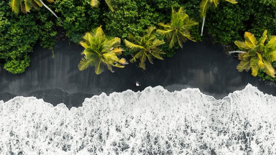 Schwarzer Strand mit Palmen auf Bali