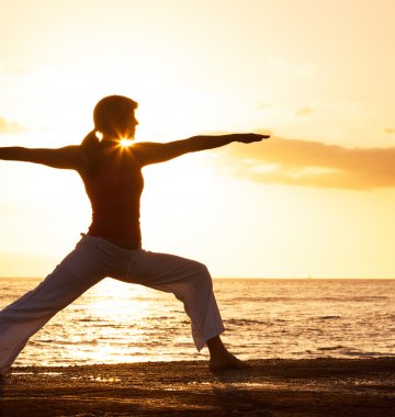 Yoga-Übung Krieger 1 Virabhadrasana am Strand