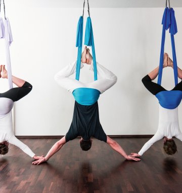Aerial Yoga verbindet Elemente des klassischen Yoga mit Elementen aus Pilates und Luftakrobatik