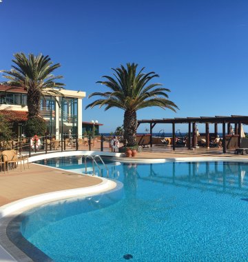 Schwimmen unter Palmen im erfrischenden Pool des Hotel Galosol
