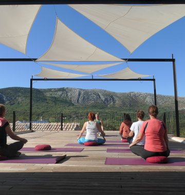 Üben Sie Yoga auf der Plattform mit Blick auf das Karstgebirge